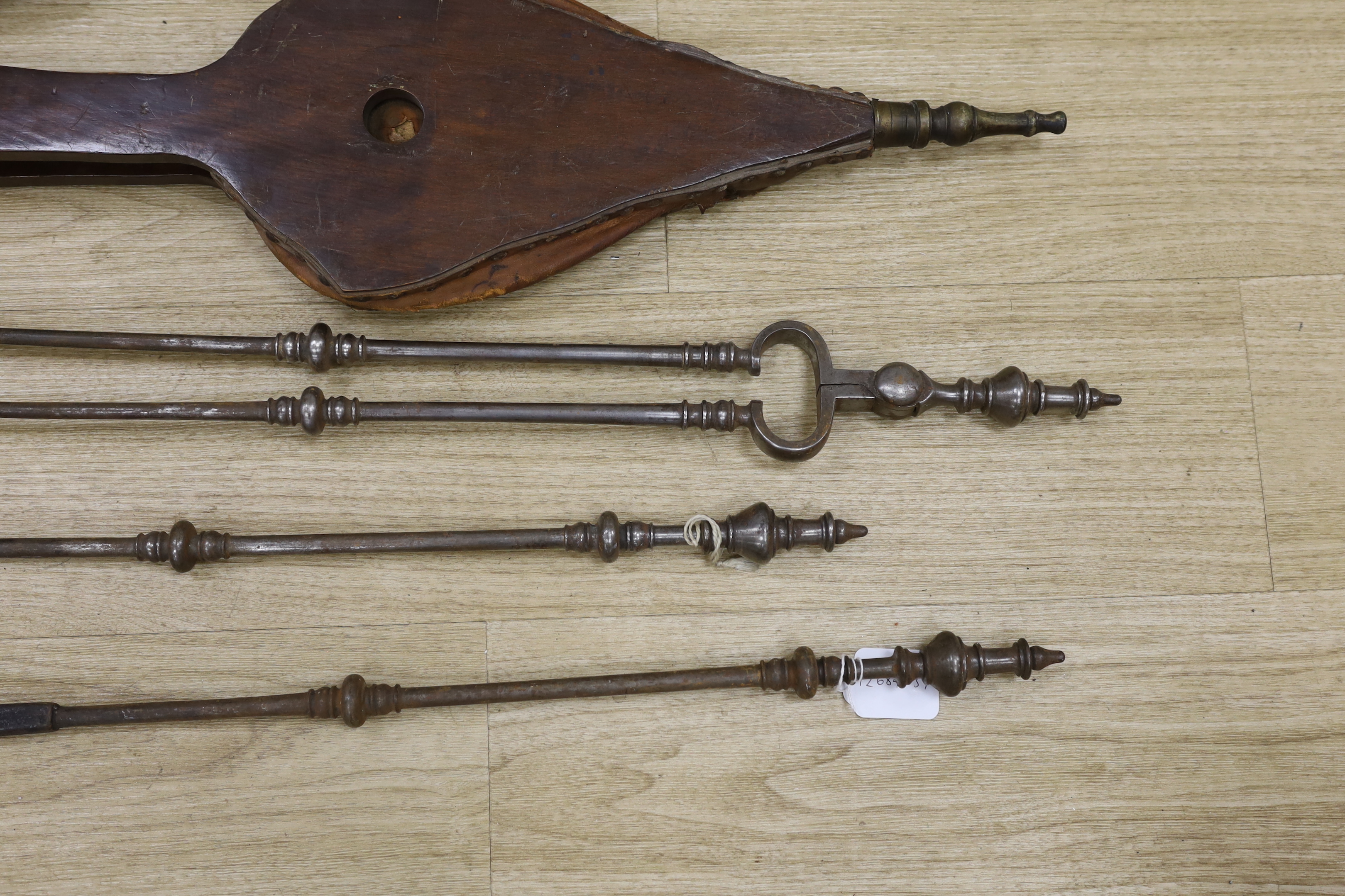 A set of three late Georgian steel fire irons, 79cm in length, together with a bellows and folding seat